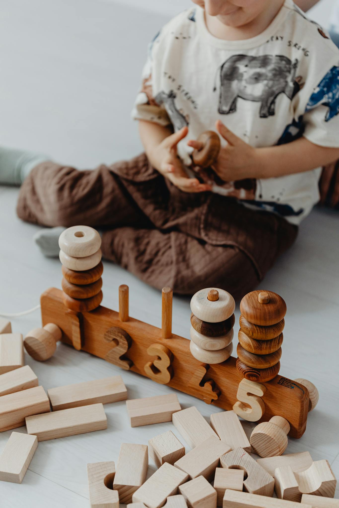 A child engaged in fun learning with a wooden stacking toy and blocks for imaginative play.