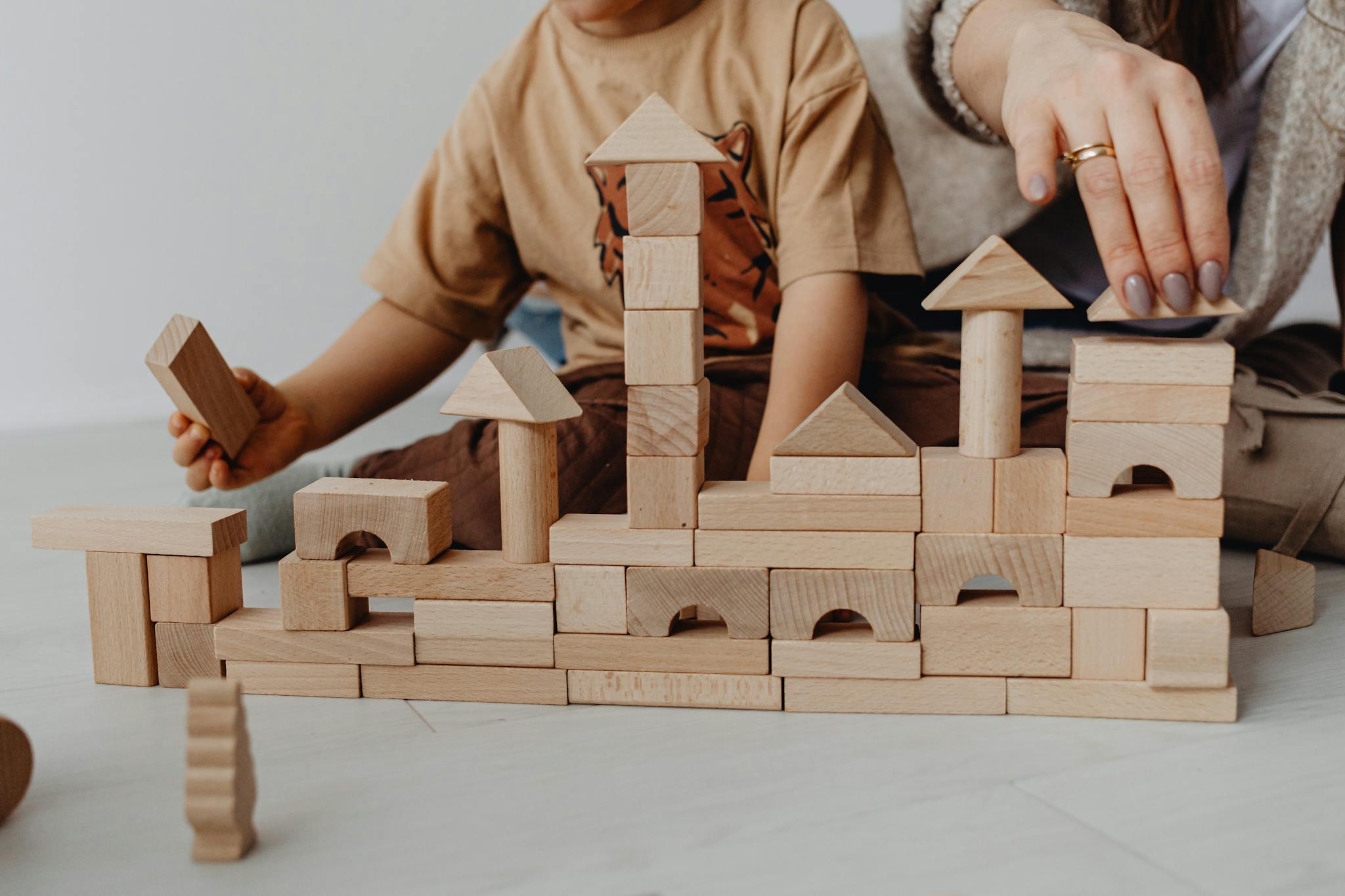 A child plays with hand-crafted wooden blocks, fostering creativity and learning indoors.